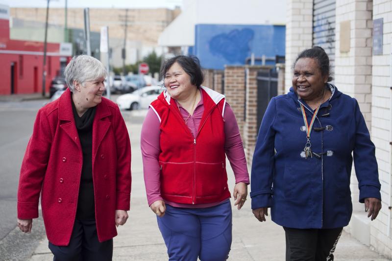 Three women smiling in the street