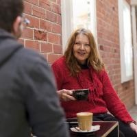 A carer having coffee with another person