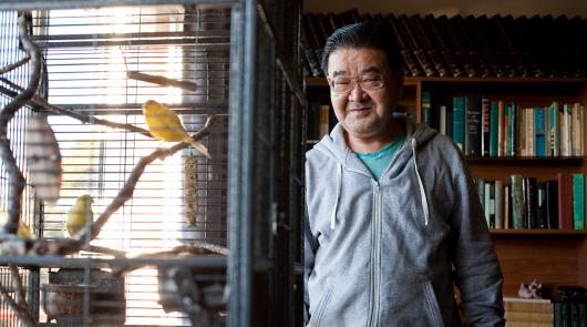 A man looking at birds in a cage